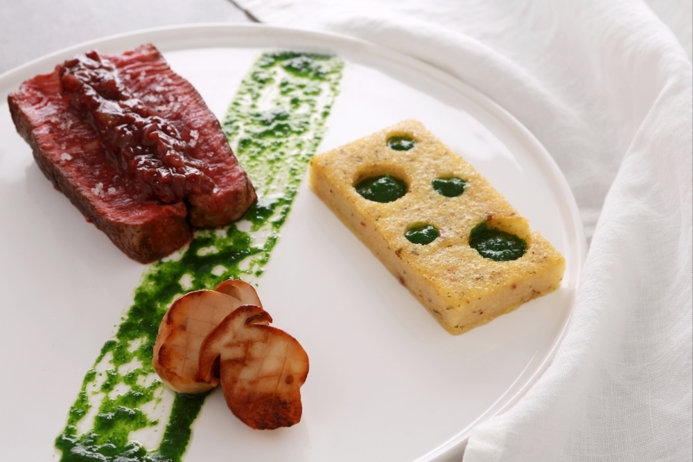 Pièce de boeuf aux échalotes confites au vin rouge, croustillant de polenta aux cèpes, coulis persillé